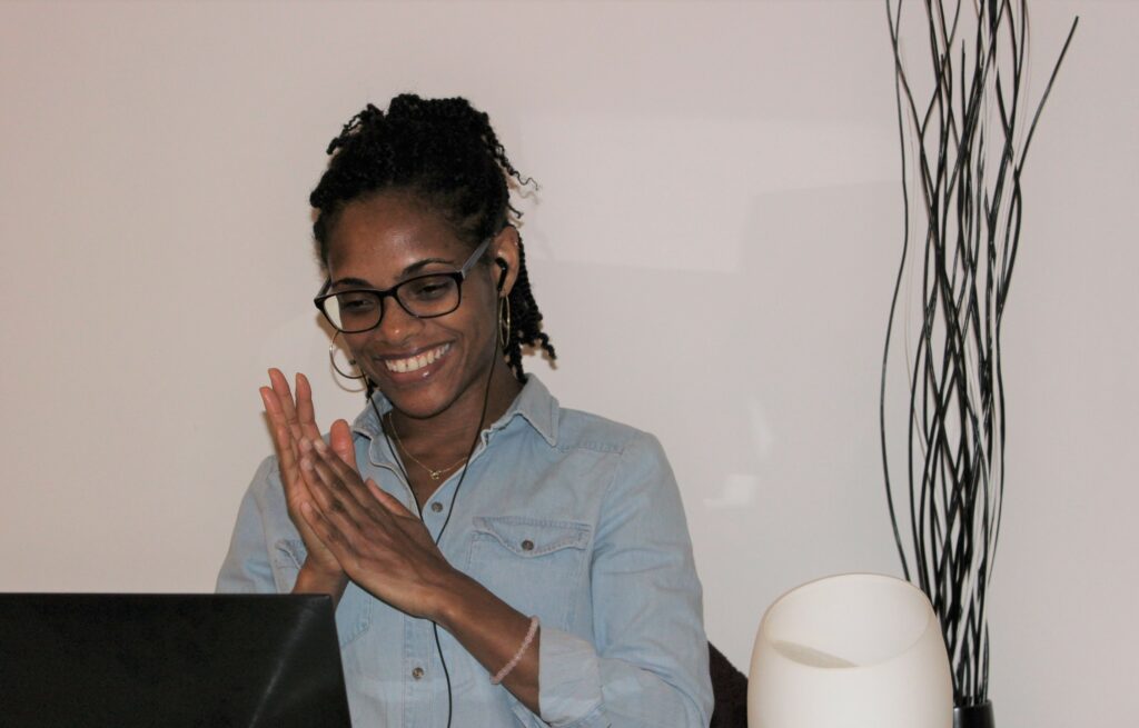 Photo de Carine Racon souriant devant son PC, une des composantes de son image de marque et son personal branding