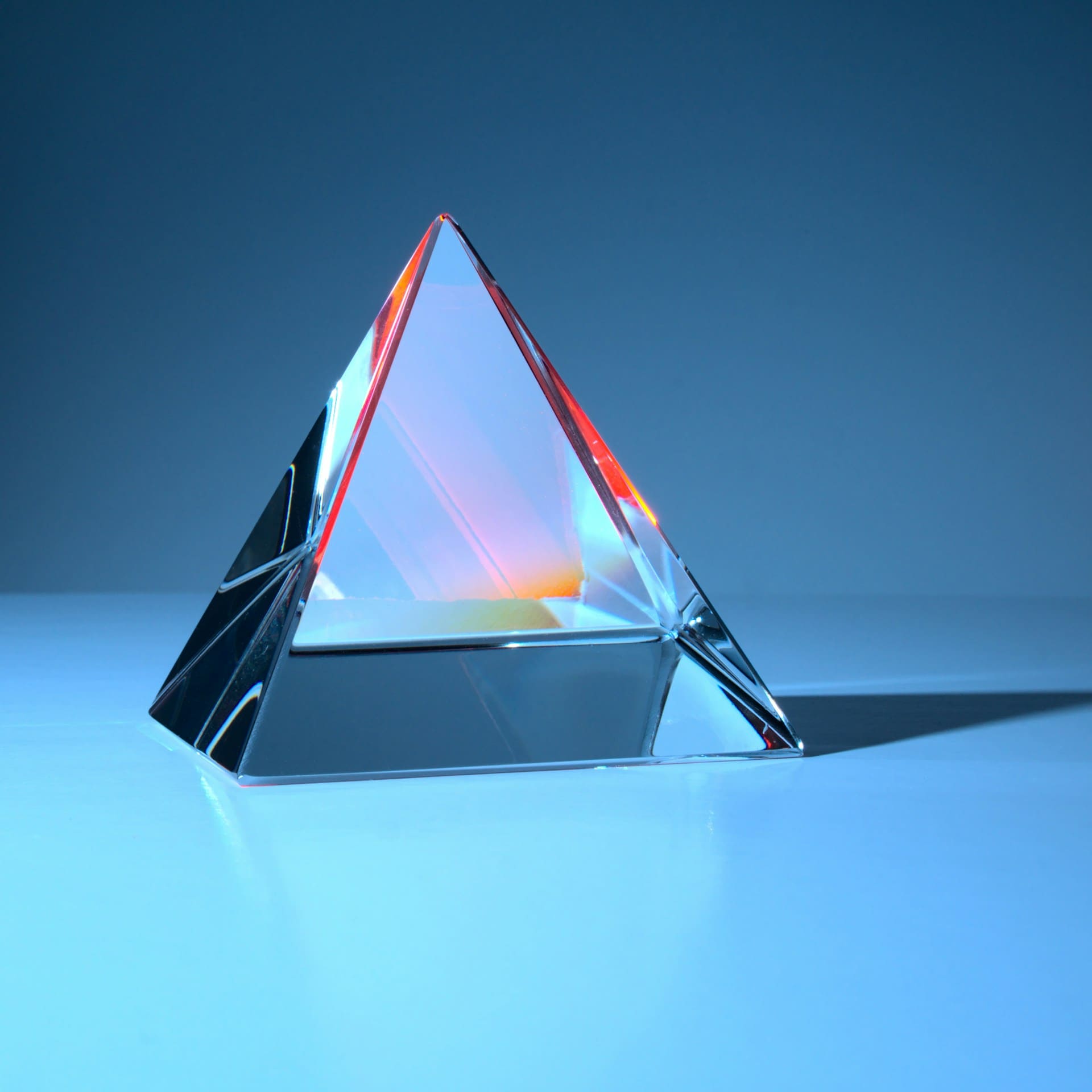 Voici une pyramide en diamant sur un fond bleu, représentant la sublimation du projet d'un futur entrepreneur, à travers l'organisation d'un événement sur-mesure.