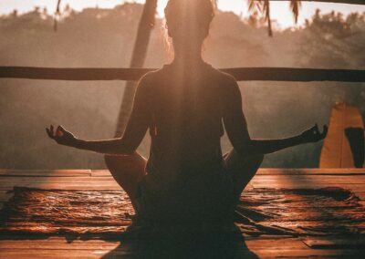 Jeune femme faisant du yoga en plein air, au lever du soleil, et faisant la pose du lotus.