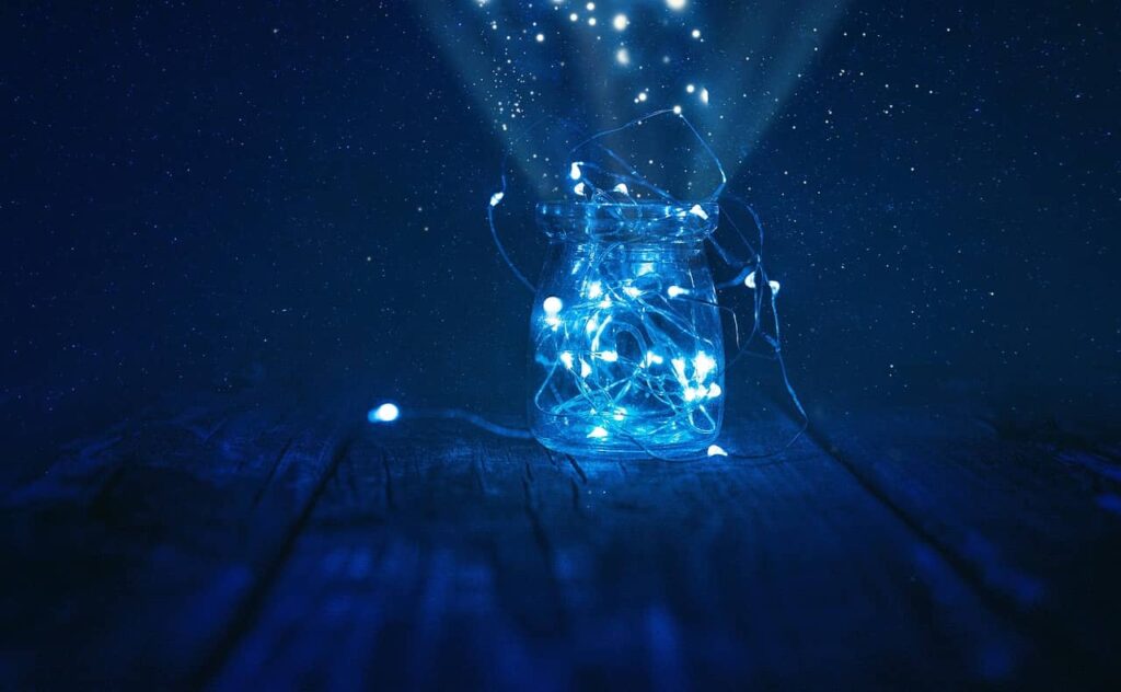 Bocal ouvert avec des minis lanternes lumineuses sortant de celui-ci