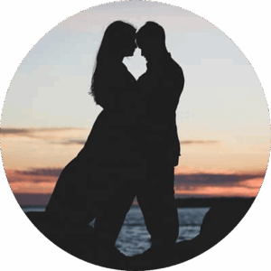 Couple Couple s'enlaçant devant l'océan et un coucher de soleil orangé