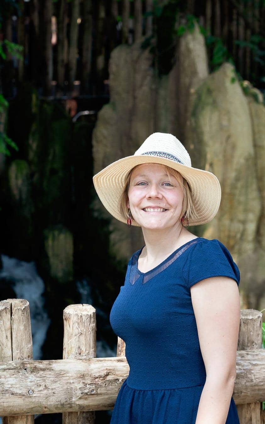 Photo HélÚne HélÚne, coordinatrice de mariage, souriante, portant un chapeau classe et moderne et un t-shirt bleu foncé