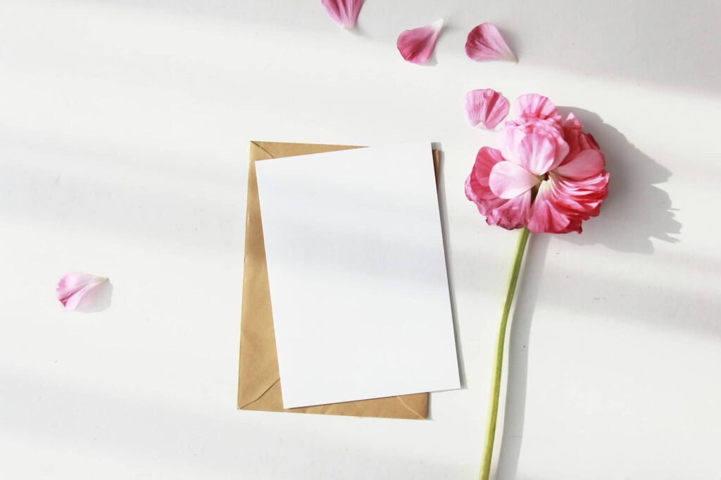 Carte d'invitation pour un anniversaire à thème, avec une rose et ses pétales qui s'envolent